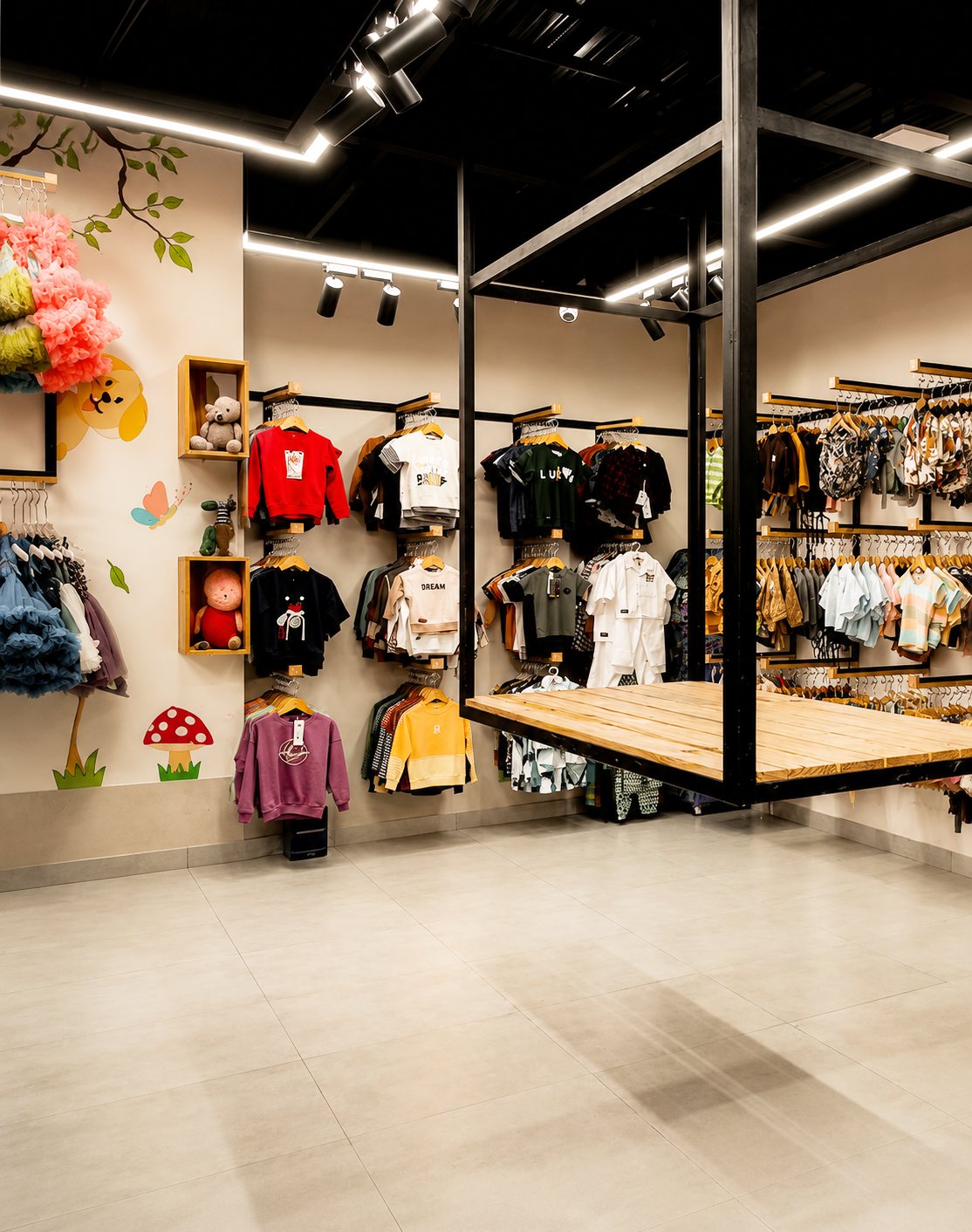 Wide shop corner with suspended clothing rails, a wood platform and woodland wall illustrations